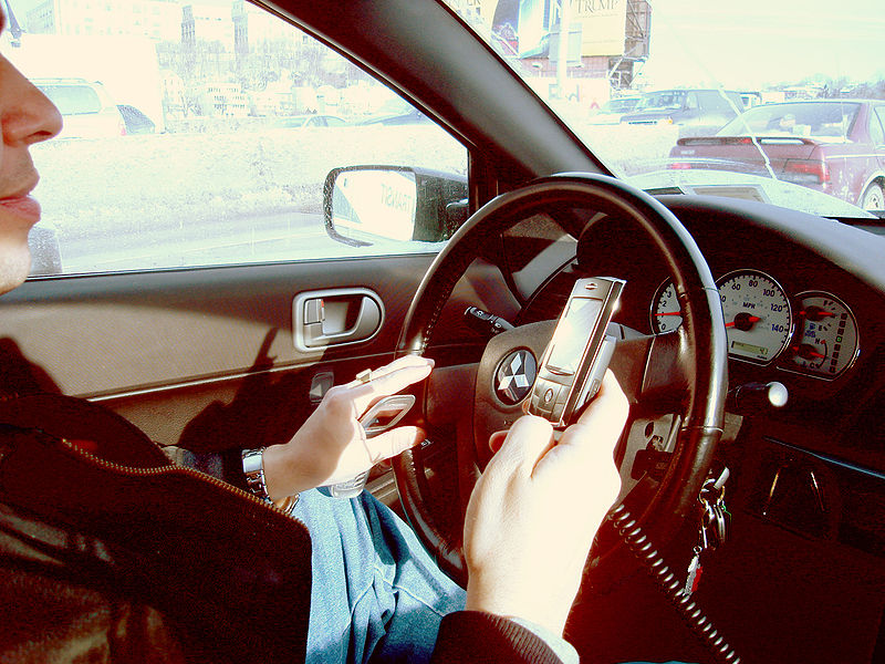 Man using a hand held mobile phone while driving