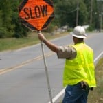 Road worker holding "Slow" sign