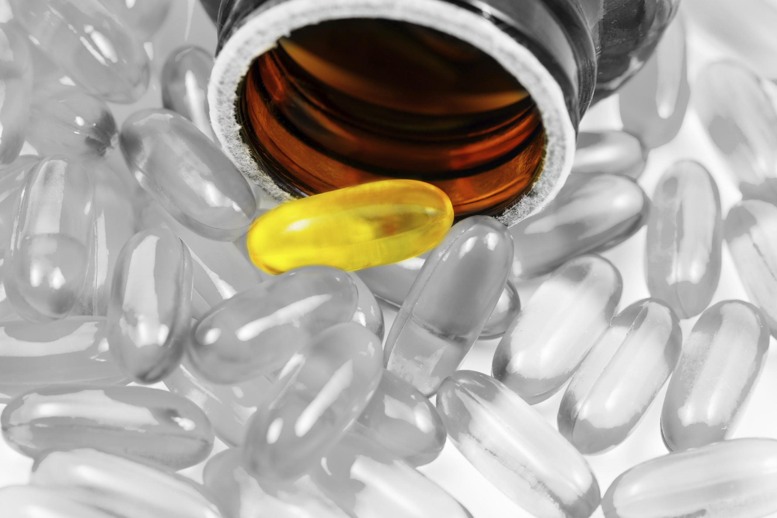Fish oil pills spilled from container split tone