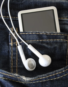 MP3 player sticking out of jean pocket, with earbuds dangling.