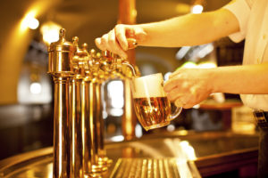 gold beer in the hand and beer taps