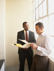 Two businessmen discussing documents in an office
