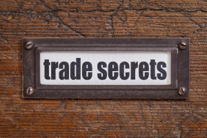 trade secrets text - file cabinet label, bronze holder against grunge and scratched wood