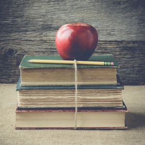 books and apple on retro background with Instagram Style Filter