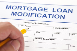 39453932 - mortgage loan modification application form and human hand with pencil.