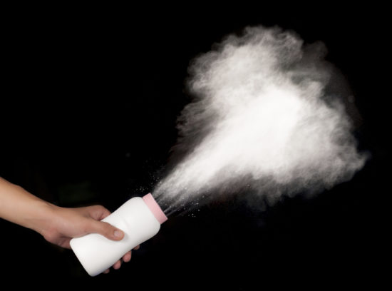 spilled baby powder on black background