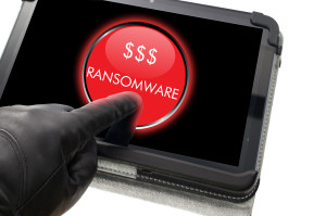 Hacker wearing black glove clicking on ransomware button