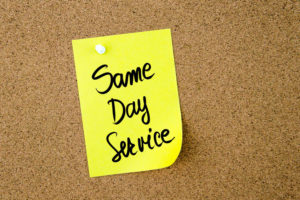 57112490 - same day service written on yellow paper note pinned on cork board with white thumbtack, copy space available