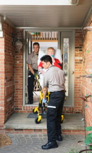 Paramedics carrying patient out of house on stretcher