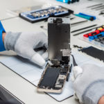 Technician replacing the screen of a used smartphone