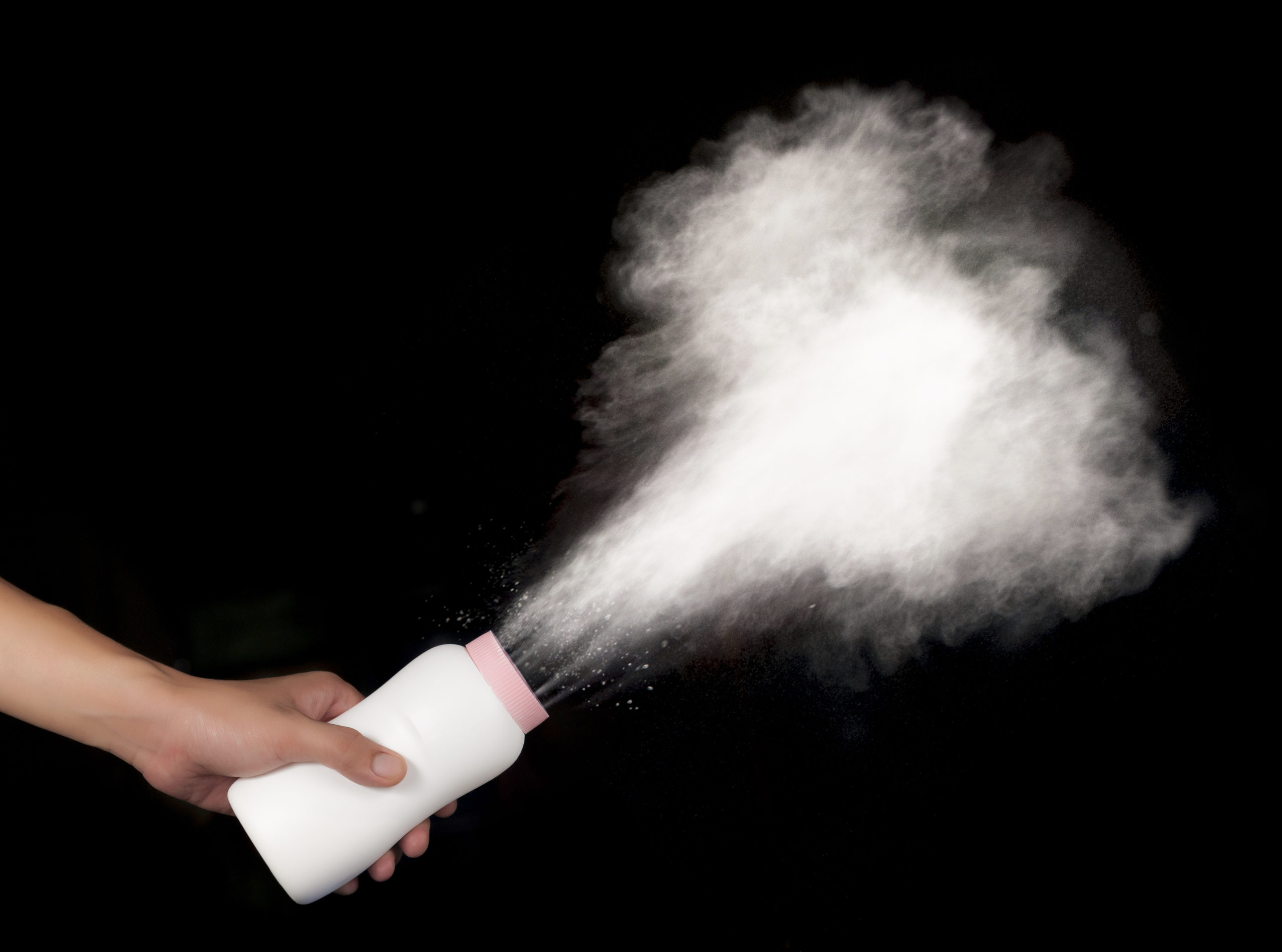 spilled baby powder on black background