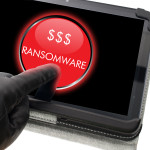 Hacker wearing black glove clicking on ransomware button