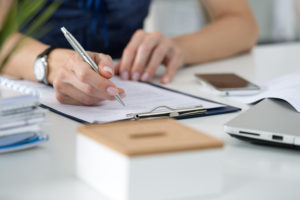 Woman writing something sitting at her office