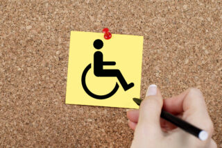 Disabled sign pinned on cork noticeboard