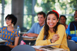 Student laughing at desk in classroom