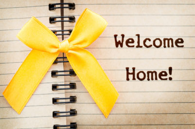 The words Welcome Home written on a old brown diary paper