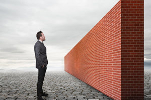 Businessman Looking at Brick Wall