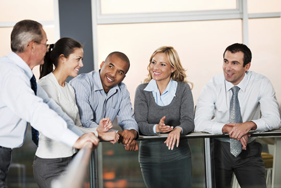 Group of businesspeople talking in a lobby.