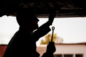 Silhouette of mechanic in an auto repair shop
