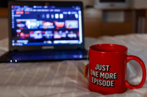 Watching streaming television with a cup of tea with inscription "Just One More Episode"