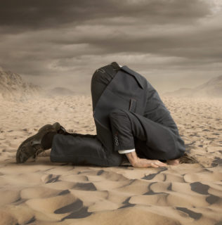 Person hiding head in the sand
