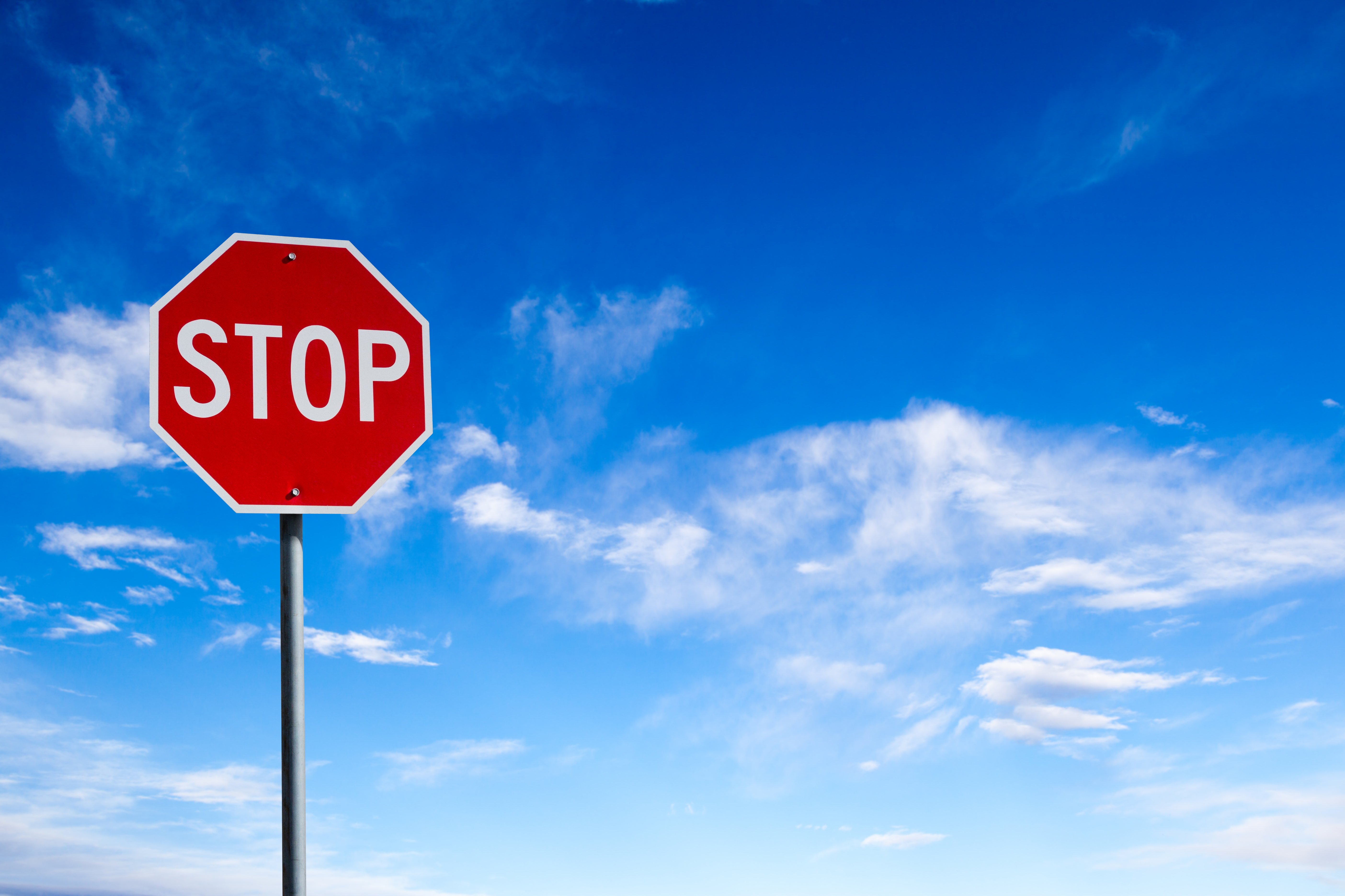 Stop Sign With Blue Sky Background and Copy Space