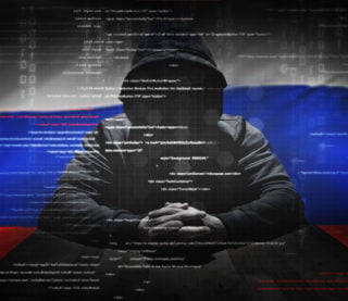 Hacker at work with Russian flag on background