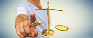 Person with finger on the scales of justice, illustrating concept of divorce
