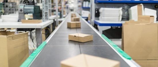cardboard-boxes-on-conveyor-belt-at-distribution-warehouse-picture-id875013806