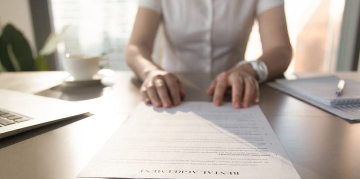 Real estate agent offers client to sign rental agreement, closeup