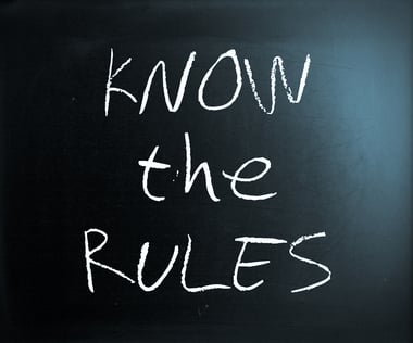 "Know the rules" handwritten with white chalk on a blackboard