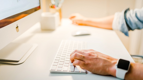 A man is checking his computer to optimize how he sends emails for his not-for-profit.