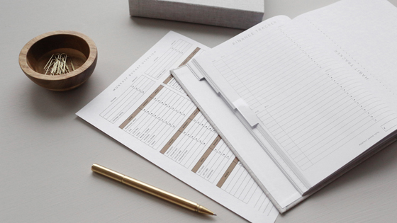 A photo of sheets of paper and a notebook being used to calculate the taxes from Social Security benefits.
