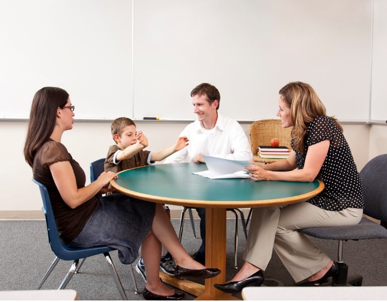 parent-and-teacher-conference-in-a-classroom-picture-id157676017