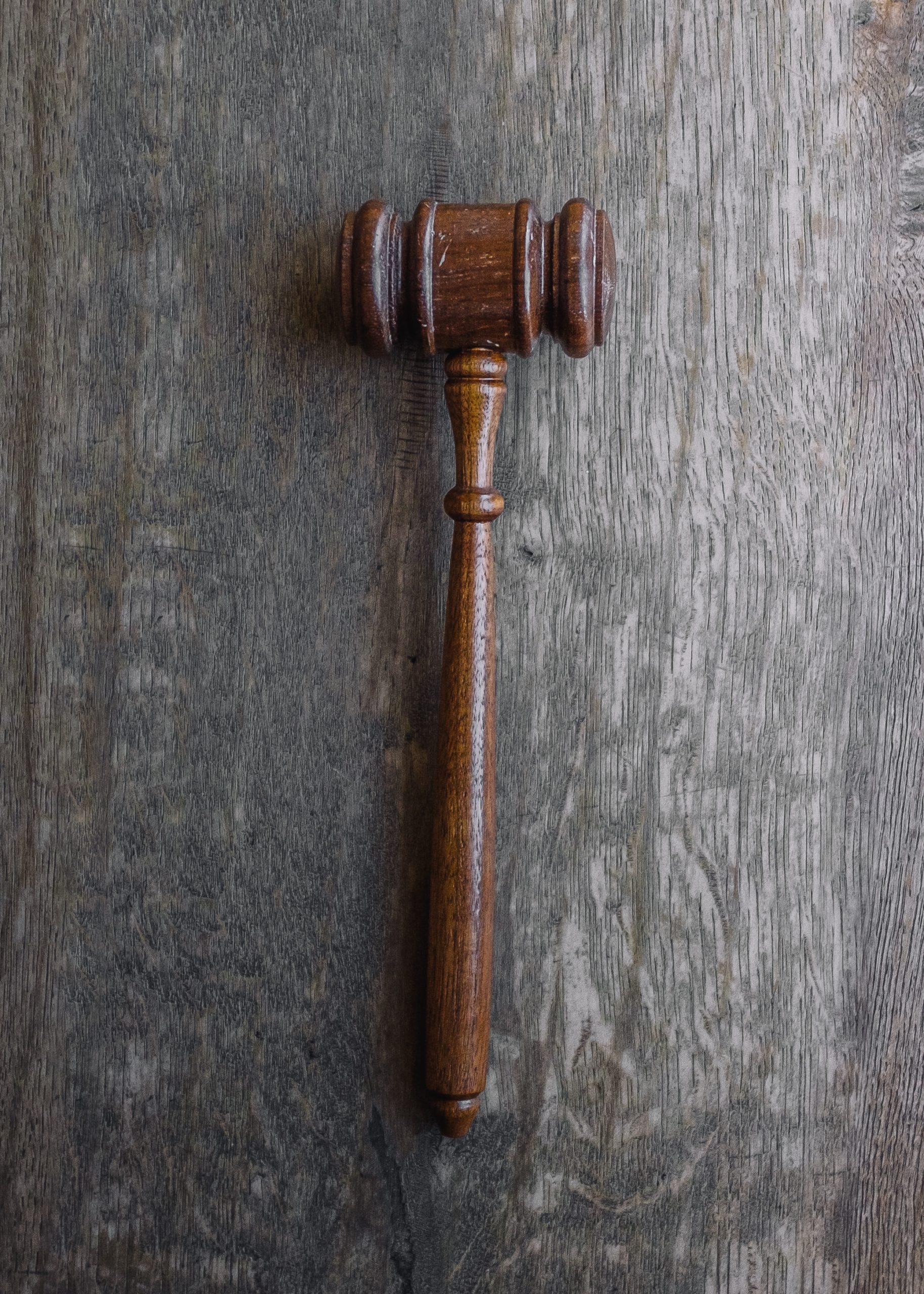 Single gavel laying alone on flat wood surface