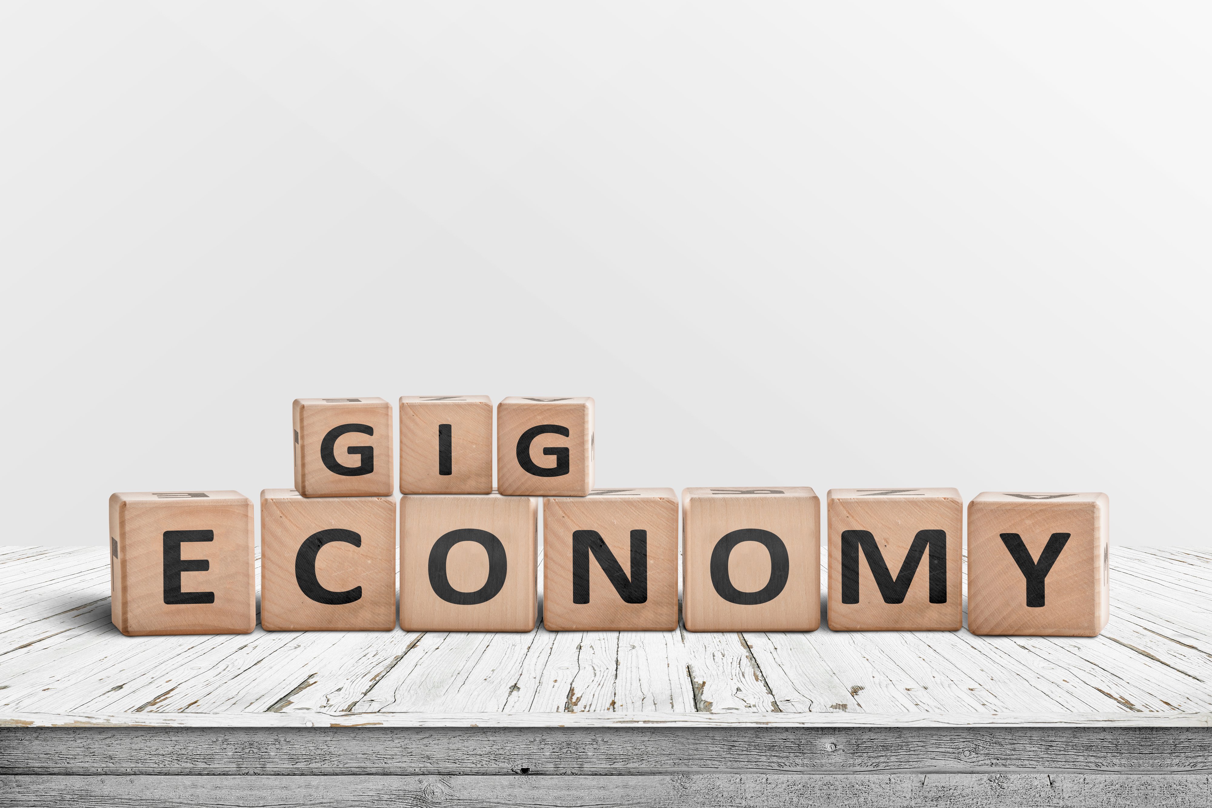 Gig economy sign made of wood on a worn table