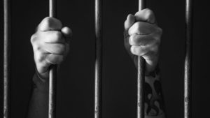 prisoner-behind-bars-300x169.jpg