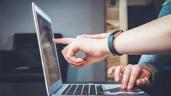 someone pointing to a laptop screen; image used for blog post about finding next executive for not-for-profit