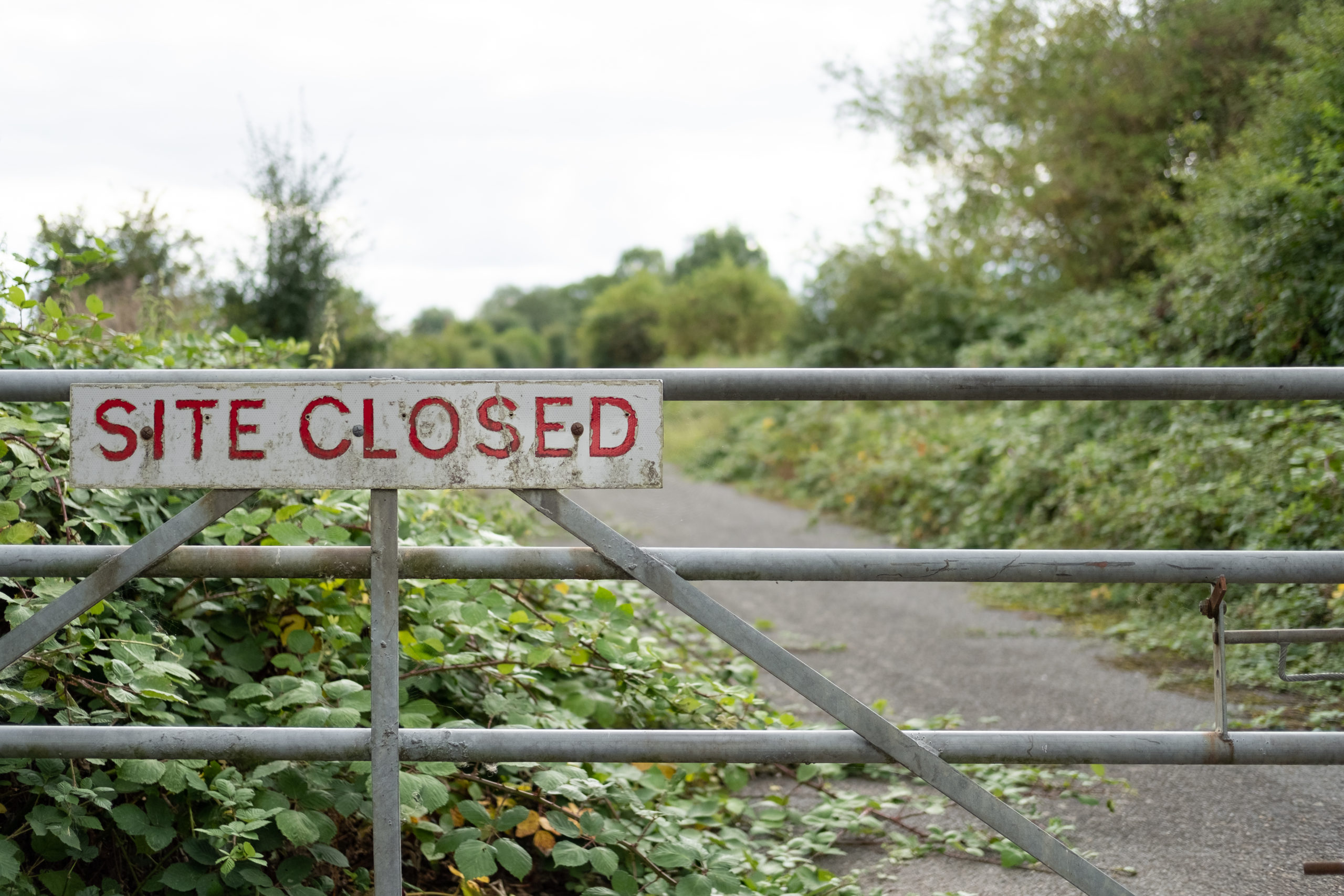 Improvised Site Closed sign seen on the entrance to a once busy factory.