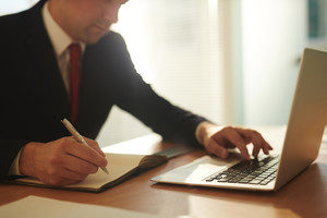 Businessman planning work and browsing in the net by workplace
