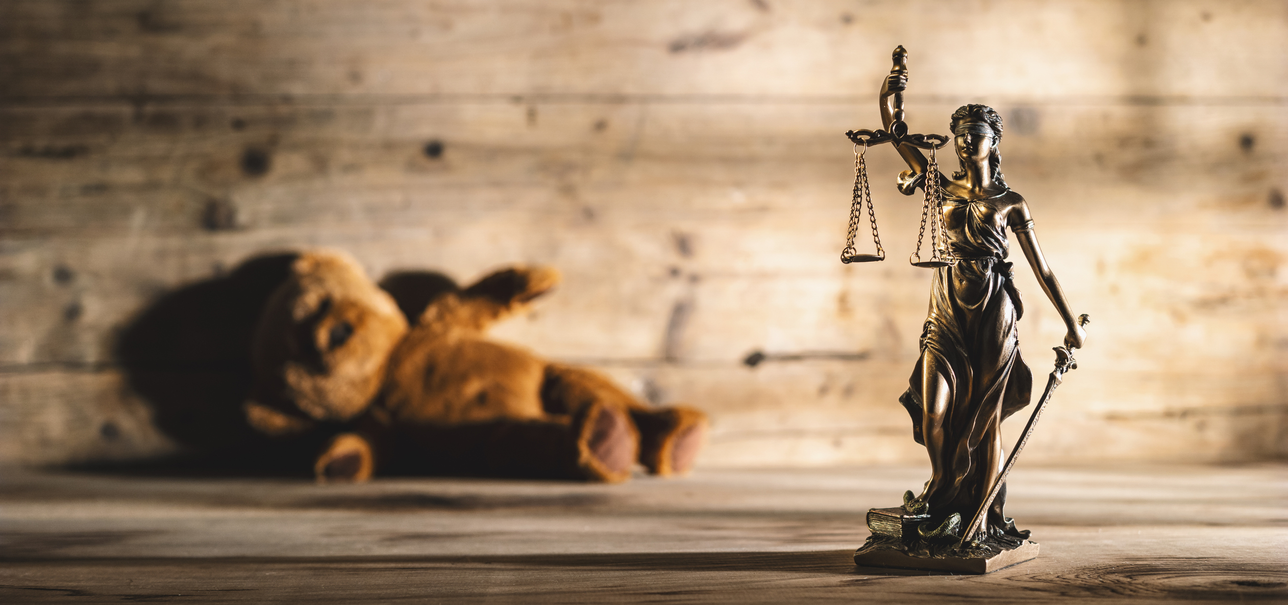 The Statue of Justice symbol with teddy bear, legal law rape concept image