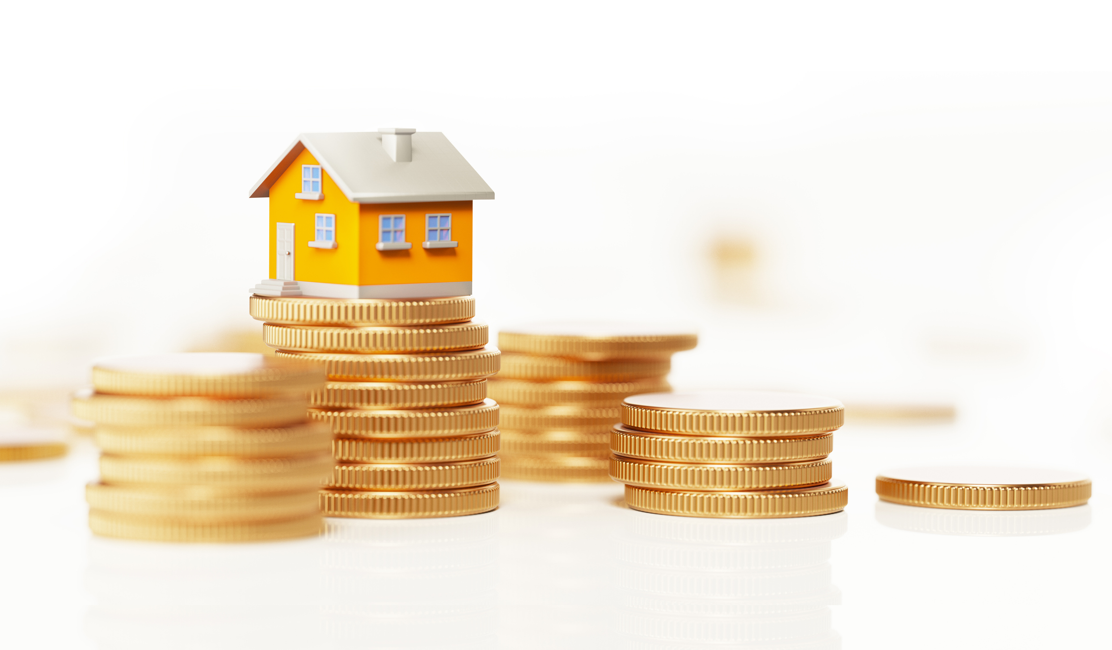 Yellow Toy House Sitting On Top Of Coin Stack: Real Estate and Savings Concept