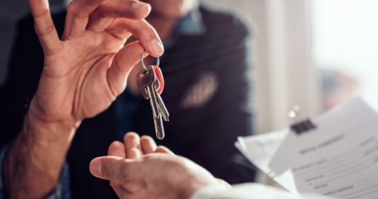 real-estate-agent-passing-keys-to-his-client-picture-id1132329631