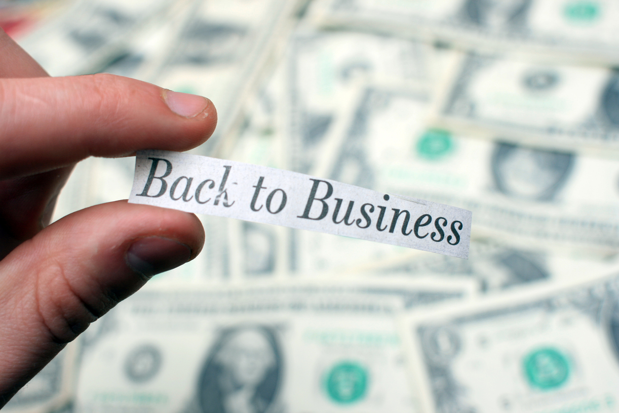 "Back to Business" - Positive Newspaper Headline Against Dollar Bills