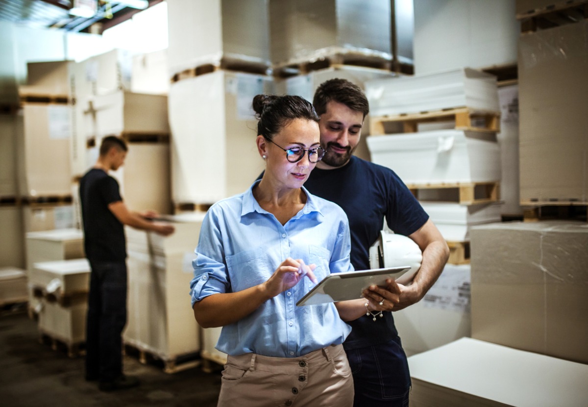 warehouse-supervisor-walking-and-talking-with-senior-manager-picture-id1160700188