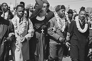 Dr Martin Luther King Jr (1926 - 1990), arm in arm with Reverend Ralph Abernathy, leads marchers as they begin the Selma to Montgomery civil rights march from Brown's Chapel Church in Selma, Alabama, US, 21st March 1965; (L-R)an unidentified priest and man, John Lewis, an unidentified nun, Ralph Abernathy (1926 - 1990), Martin Luther King Jr (1929 - 1968), Ralph Bunche (1904 - 1971) (partially visible), Abraham Joshua Heschel (1907 - 1972), Fred Shuttlesworth (1926 - 1990). (Photo by William Lovelace/Daily Express/Hulton Archive/Getty Images)