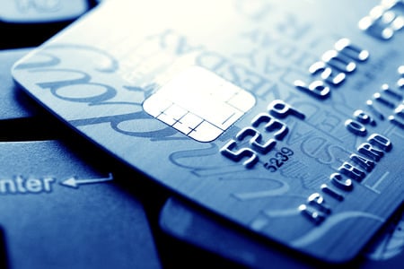 Close up of credit card with chip and numbers, dark blue theme