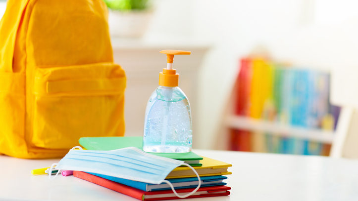 Backpack of school child. Face mask and sanitizer.