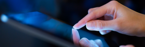 Close-up of hand scrolling on tablet