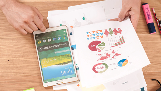 man looking at documents with data and charts; image used for blog post about mutual funds tax pitfalls